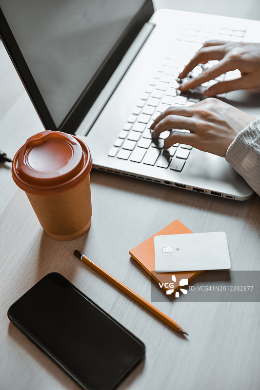 用信用卡喝咖啡的女性完成笔记本电脑金融工作图片素材