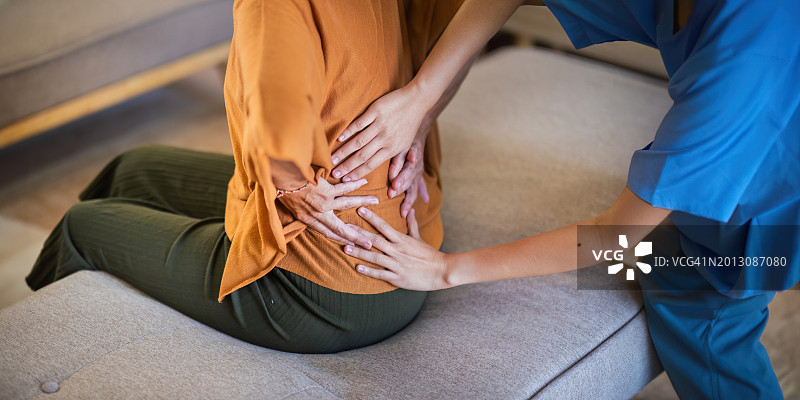 在家中床上因胃痛而坐卧的女子图片素材