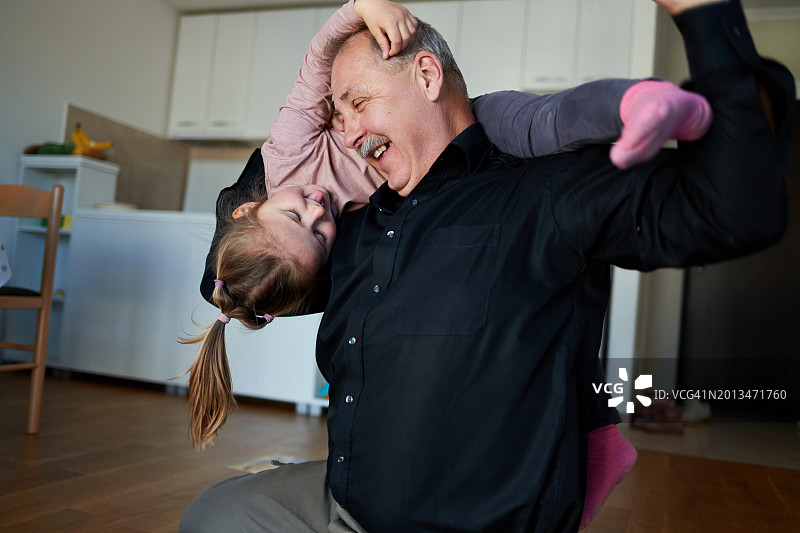 爷爷在玩耍时把孙女扛在肩上图片素材