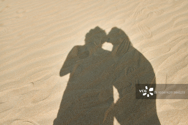 情侣在海滩上影子接吻图片素材
