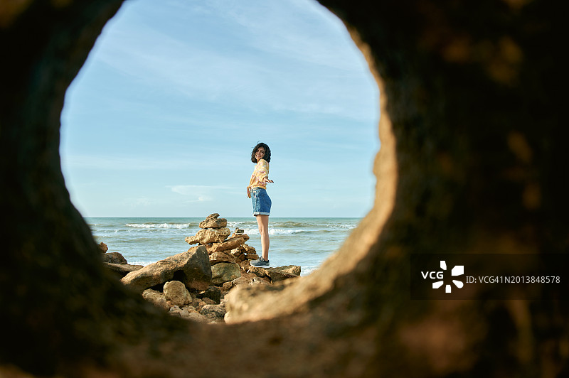 在哥伦比亚瓜希拉蓬塔加利纳斯海滩的石头上的女人图片素材