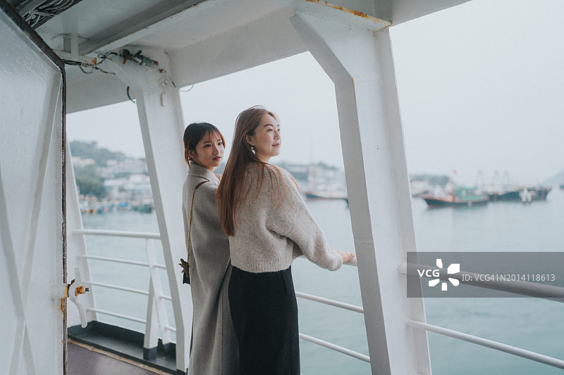 在船上欣赏海景的两位年轻亚洲女性的中景镜头图片素材