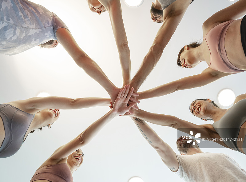 一群朋友在健身房里手叠手图片素材