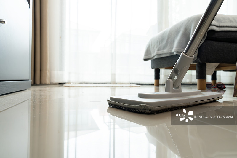 用拖把擦拭客厅地板图片素材