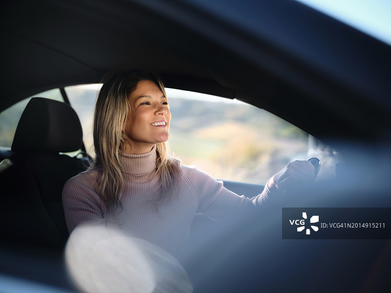快乐的女人在旅途中开车图片素材