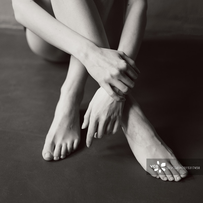手放在脚上的年轻女人图片素材