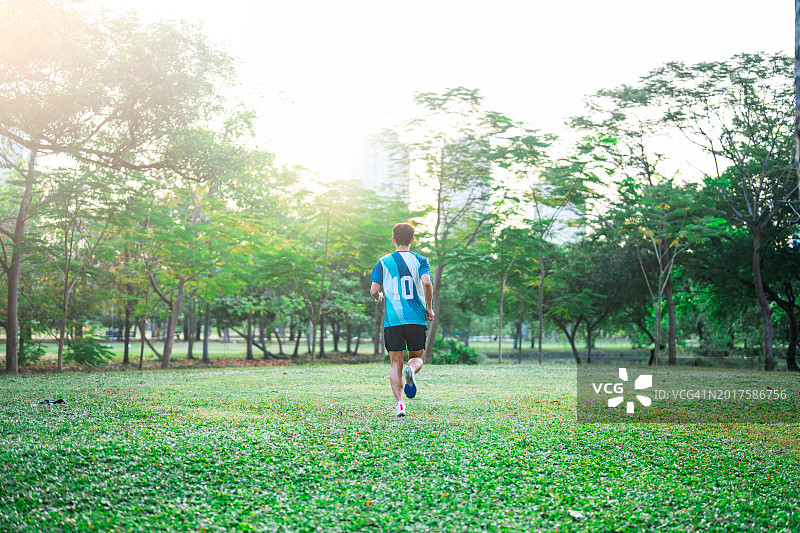 在户外慢跑并查看智能手表的亚洲青年男子图片素材