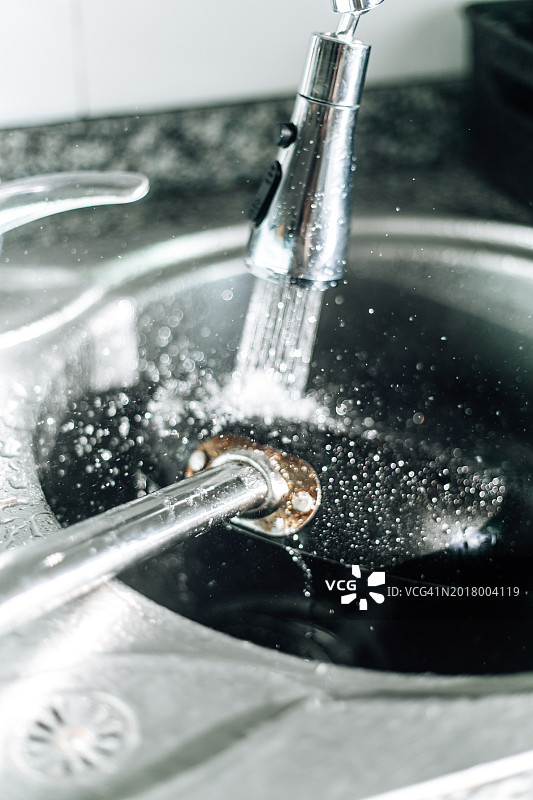 厨房水槽上水流冲刷着烹饪锅图片素材
