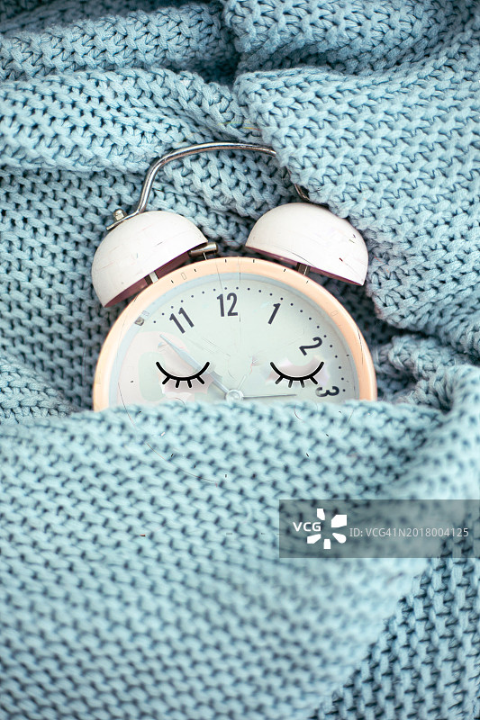 粉色闹钟在床上睡觉图片素材