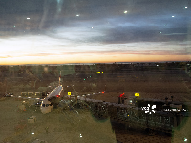 日出前起飞的商用喷气式飞机轮廓图片素材