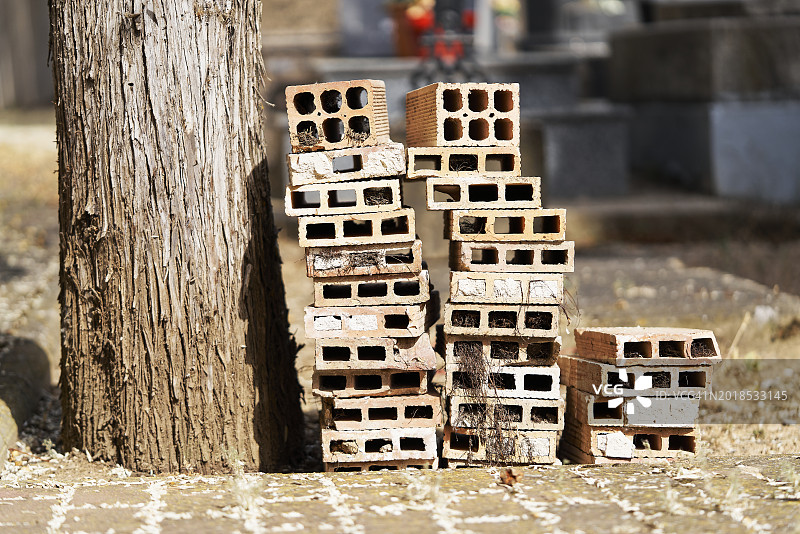 街道上树旁一侧堆叠的一组砖块侧视图图片素材