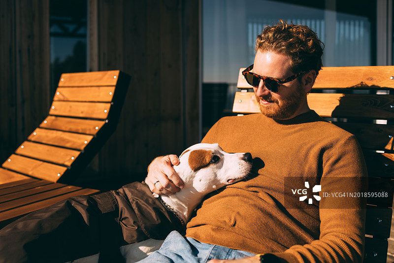 放松的男人和他的狗在户外享受阳光图片素材