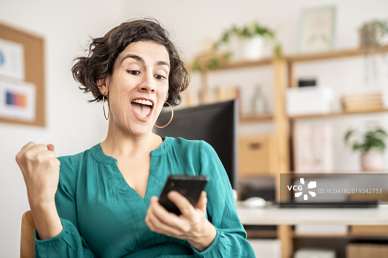 在手机上阅读令人惊讶短信的休闲女商人图片素材