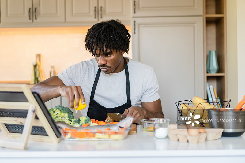 男人使用笔记本电脑学习烹饪图片素材