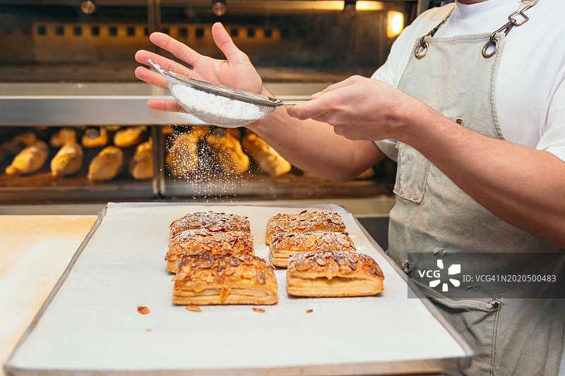 糕点师的手用糖粉完善糕点图片素材