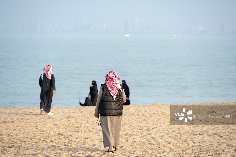 在科威特科威特市达斯曼海滩穿着传统服装的穆斯林男女图片素材