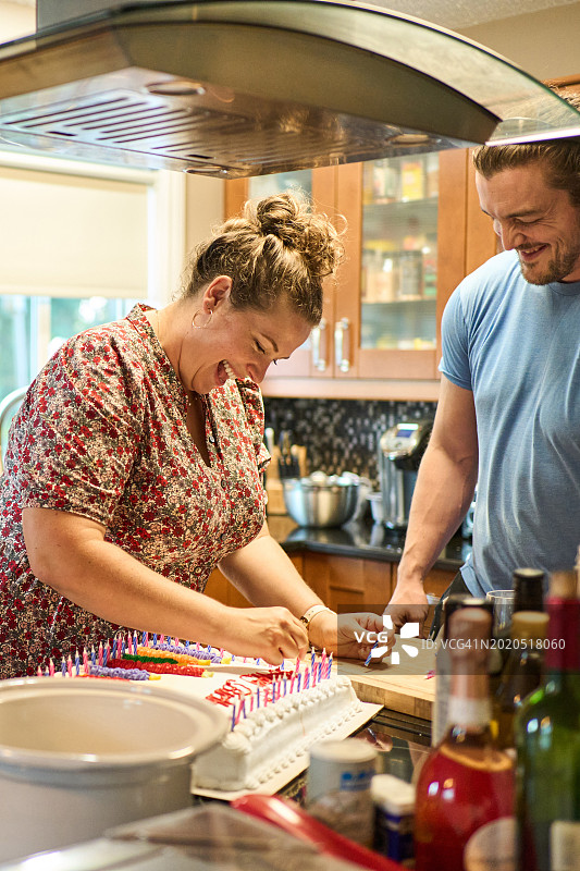 两个朋友在聚会上为生日蛋糕点蜡烛图片素材