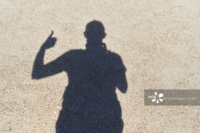 站在街上用手机的男游客的影子俯视图图片素材