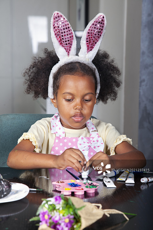 在客厅装饰复活节彩蛋的非洲裔美国小女孩图片素材
