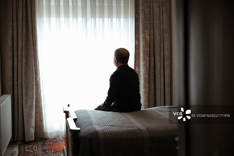 坐在床上表情严肃的老人图片素材