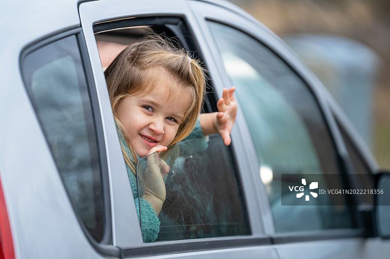 在车外窥视的微笑小女孩图片素材