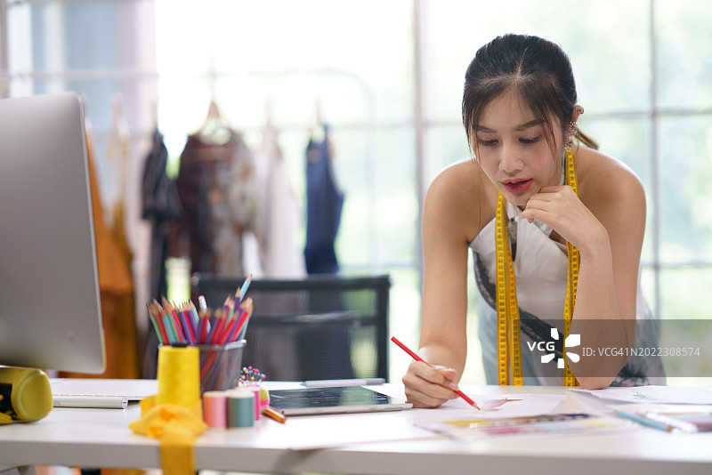 设计师在数字设备上绘制图案模型服装的草图创意图片素材