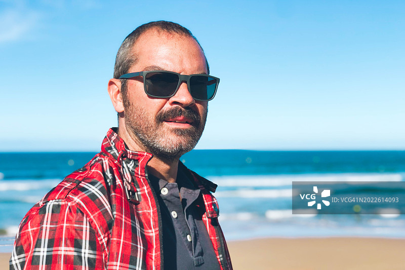 中年男人戴着太阳镜在海滩上的肖像图片素材