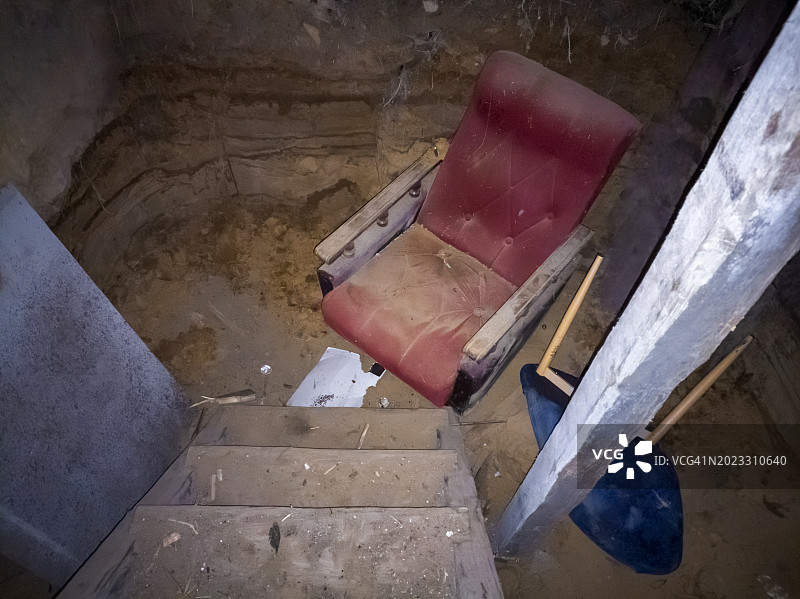 地下室里被毁坏的红色扶手椅和倾覆的椅子图片素材