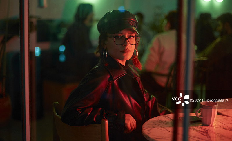 年轻女子独自坐在咖啡馆里向外看图片素材