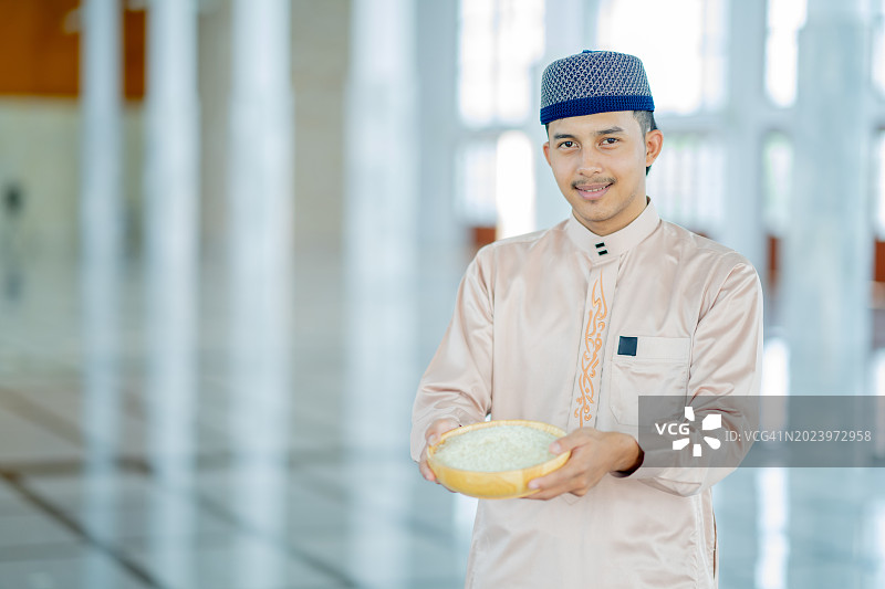 穆斯林双手捧着装有斋戒的木碗图片素材