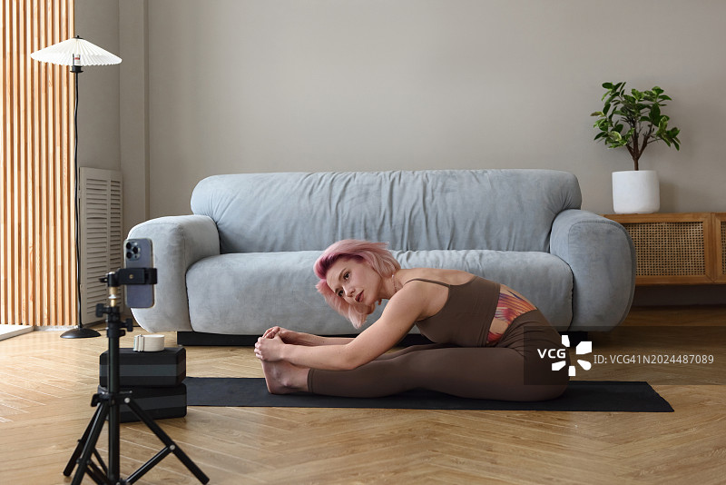 在家看视频练瑜伽的女人或在线博主培训图片素材