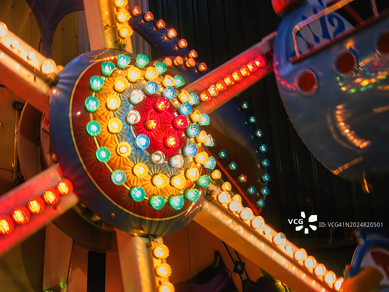 游乐设施圆形截面的彩色灯光照明横向特写镜头图片素材