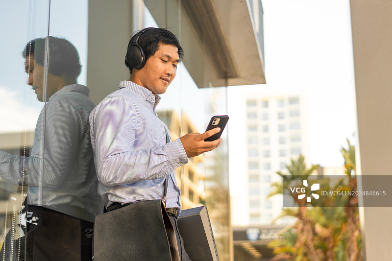 使用智能手机的年轻亚洲学生图片素材