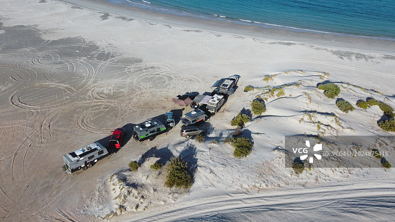 一群大篷车和拖车聚集在南澳大利亚艾尔半岛下部的海滩沙丘附近图片素材