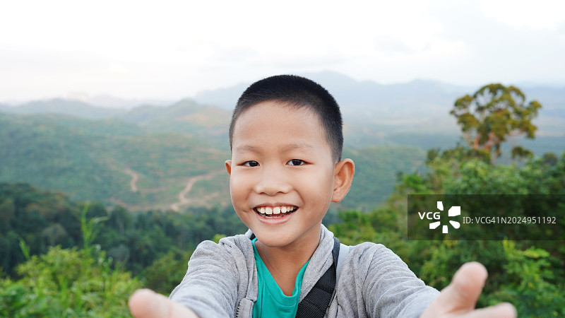 亚洲男孩户外自拍，儿童旅行与社交媒体概念图片素材