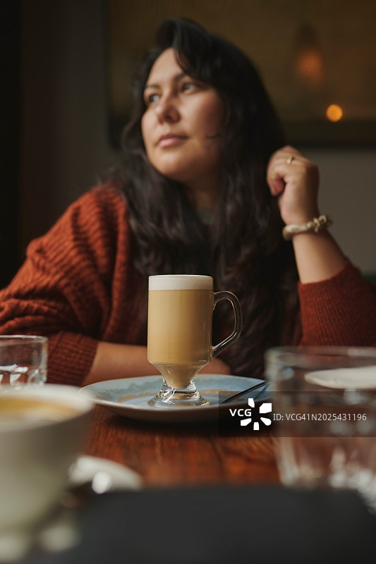 在咖啡馆喝拿铁，思考未来的女人图片素材