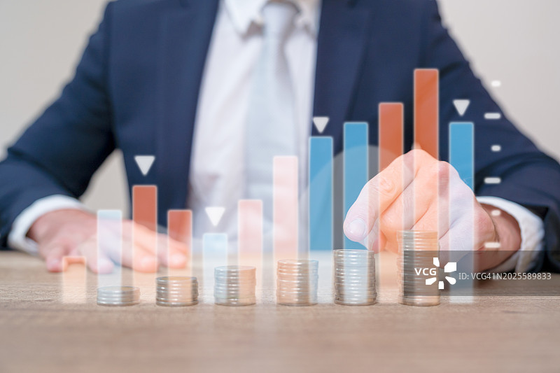 商业投资者手指点数硬币并显示全息图表数据图片素材