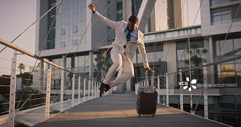 商务男士在城市桥上跳跃庆祝图片素材
