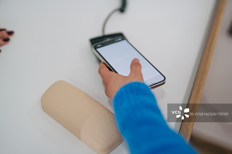 女人使用智能手机进行非接触式交易，数字支付概念图片素材