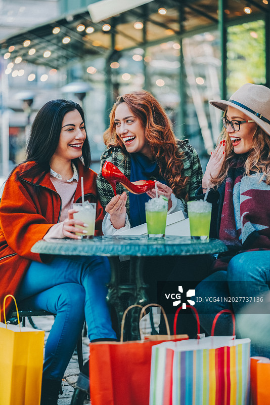 购物后在路边咖啡馆的年轻女性图片素材