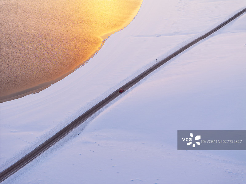 冰岛克莱瓦湖冬季日落时分的公路车辆航拍图片素材