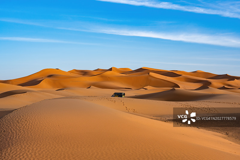 撒哈拉沙漠的越野车探险之旅：蓝色天空下的橙色沙丘，摩洛哥旅游目的地图片素材