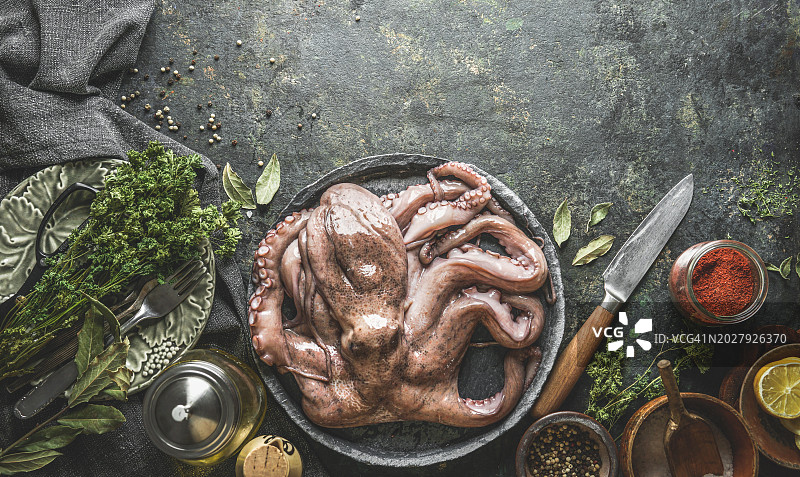 在乡村风格的餐桌上用刀和烹饪配料准备章鱼图片素材