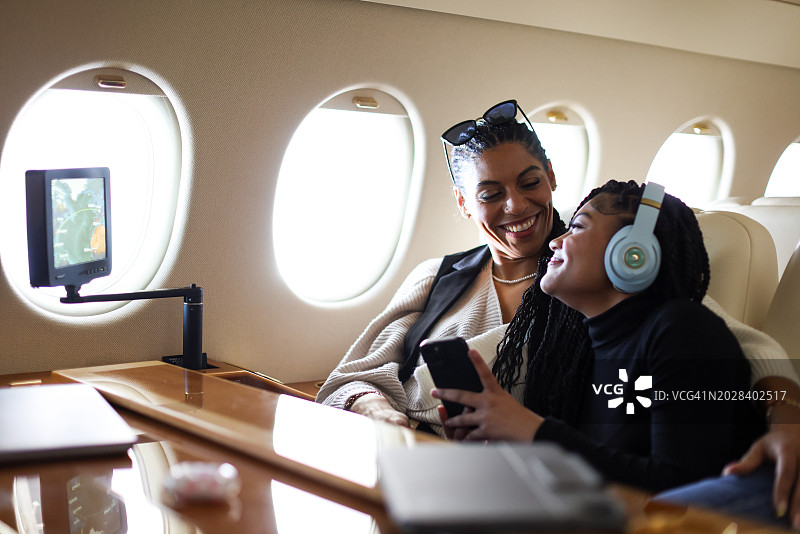 母女在私人飞机上旅行，相视而笑图片素材