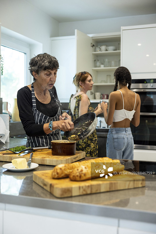 一群女朋友在现代厨房里准备派对食物图片素材