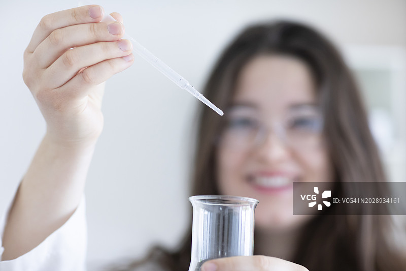 年轻女科学家在实验室戴着实验眼镜工作图片素材