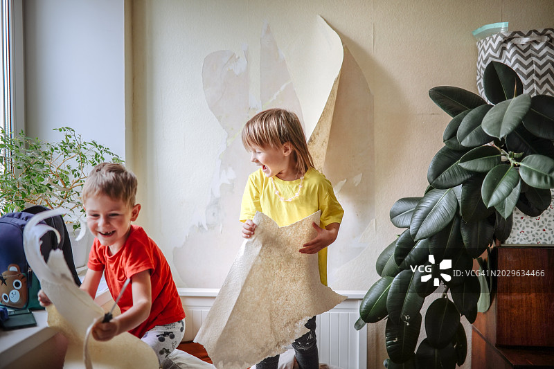 协作式家庭升级：孩子们一起快乐地去除墙纸图片素材