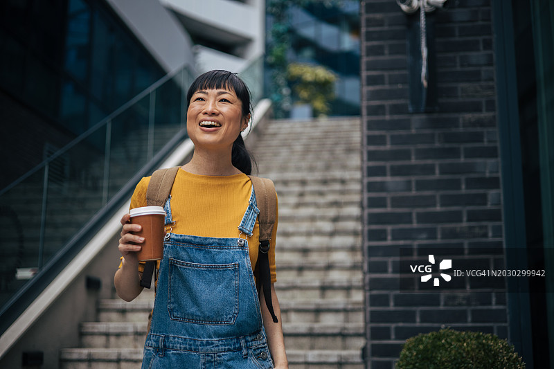 在户外手持咖啡杯的美丽日本女性画像图片素材