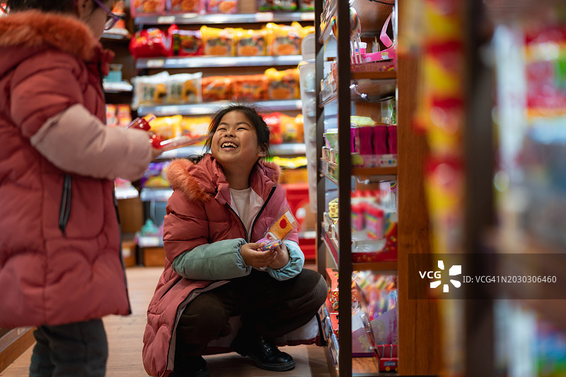 姐妹俩在商店里高兴地挑选零食图片素材