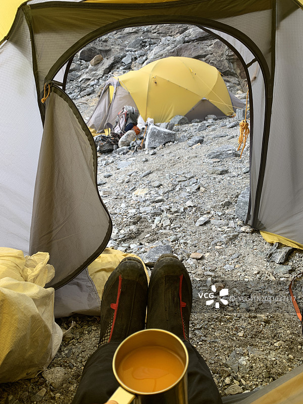 在印度喜马拉雅高山营地帐篷里喝热橙汁的登山者图片素材